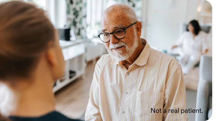 Older man speaking indoors.