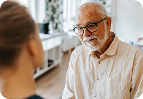 Older man speaking indoors.
